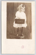Postcard RRPC Young Girl at Podium Stand Real Photo Kruxo Stamp Box